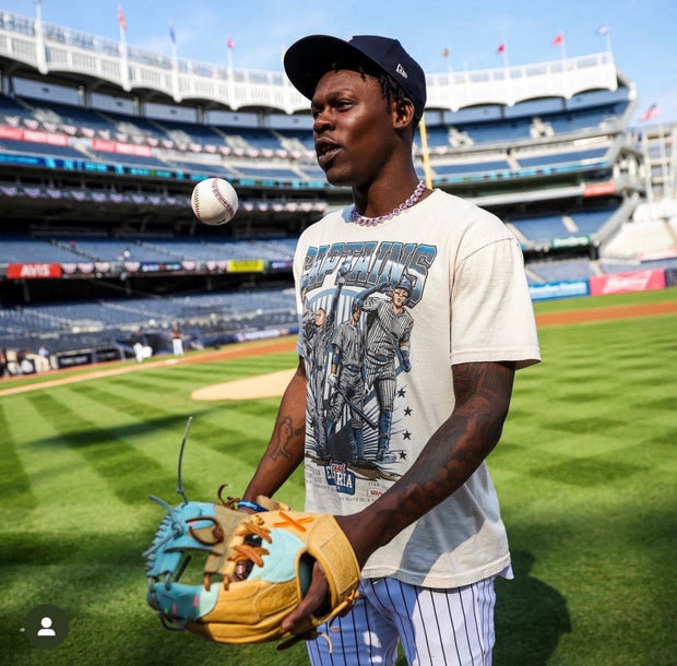 Jazz Chisholm Jr. at Yankee Stadium modeling a custom 'Captains' t-shirt by Planet Euphoria while tossing a baseball.