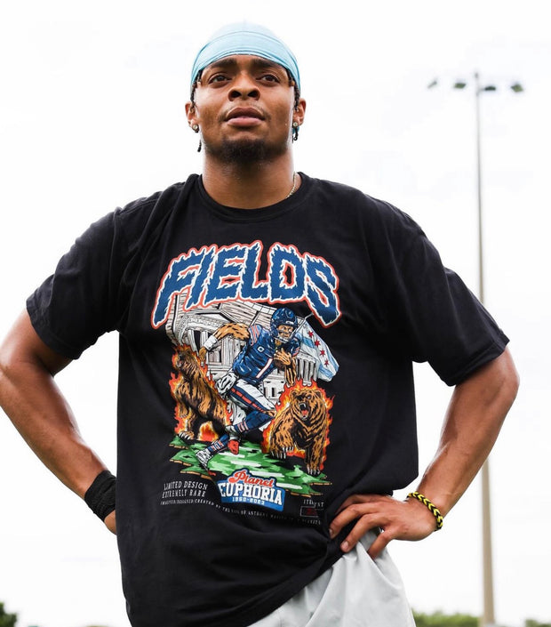 Justin Fields standing akimbo while wearing a custom graphic t-shirt with his likeness on it, made by Planet Euphoria.